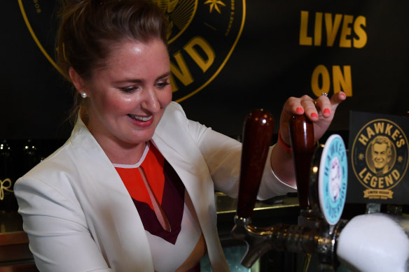 Sophie Taylor-Price, the granddaughter of the late Bob Hawke, pours the first beer during the launch of Hawke's IPA Legacy at The Clock Hotel in Surry Hills. 