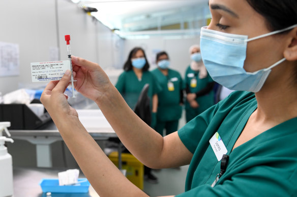 Western Health pharmacist Samira Hamidi prepares a coronavirus vaccine at the Melbourne Airport vaccination hub.