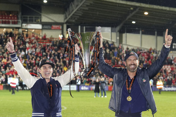 Wrexham co-owners Rob McElhenney (left) and Ryan Reynolds celebrate after their team beat Boreham Wood and clinched promotion.