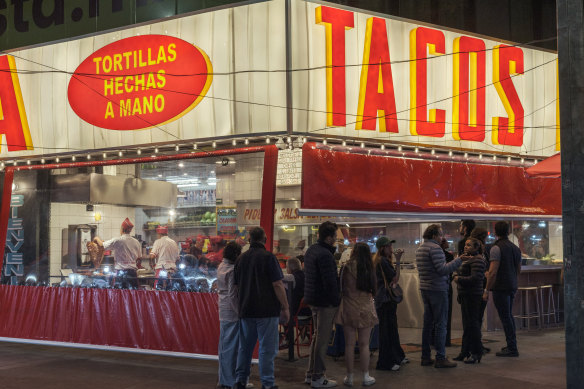 Customers line up outside La Chula taquería in Roma Sur, one of the Mexico City neighbourhoods that has become popular among tourists and international transplants.  