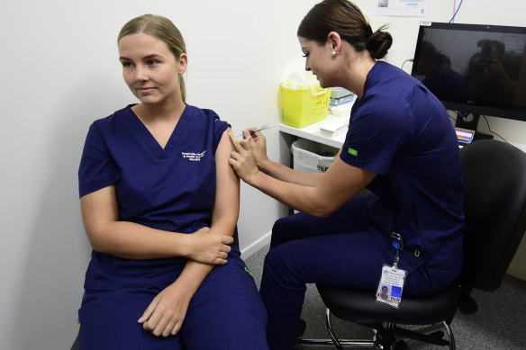 Registered nurse Rebecca DeJong receives a dose of the Pfizer COVID-19 vaccination at the Townsville University Hospital hub in March.