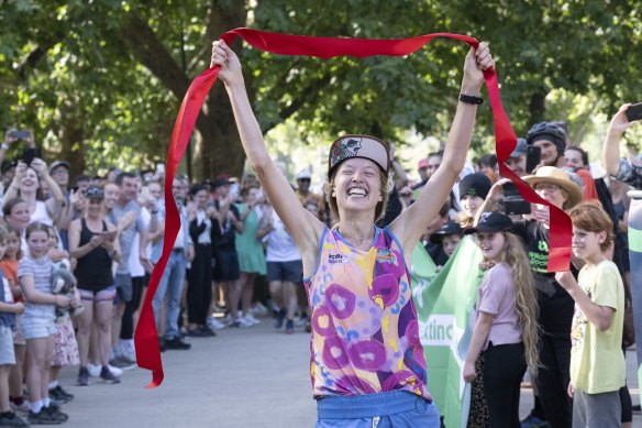 Erchana Murray-Bartlett is greeted by a guard of honour as she completes her 150th marathon in as many days at Melbourne’s Tan track on Monday evening.