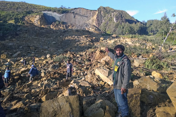 People gather at the site of a landslide in Maip Mulitaka in Papua New Guinea’s Enga Province.