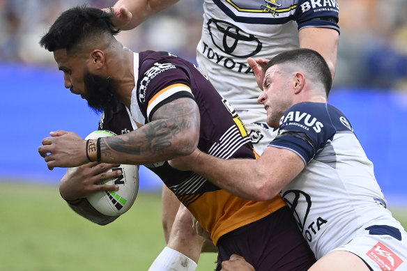 Payne Haas of the Broncos is tackled during the round 23 clash at Qld Country Bank Stadium.