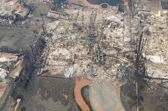 The backyard pool is visible at the rear of this property, which has been reduced to rubble.