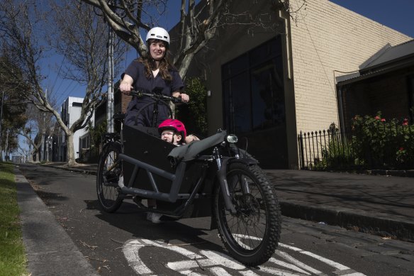 Mali Lewis with seven-month-old daughter Bea riding on a dedicated bike lane on Abbotsford Street, North Melbourne.