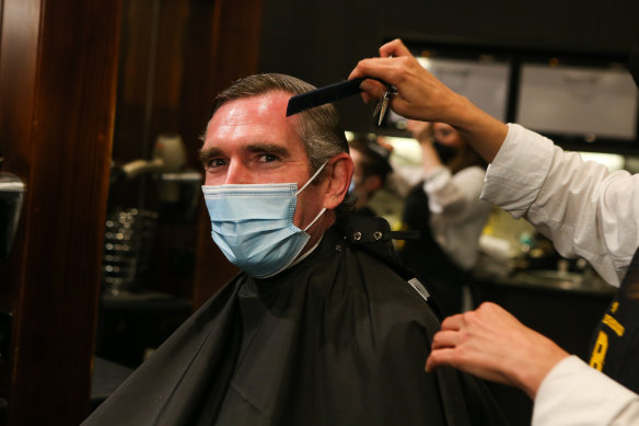 NSW Premier Dominic Perrottet receives a haircut in front of media at Barberhood in Sydney on Monday.