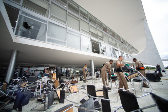 Workers clear debris caused by Jair Bolsonaro’s supporters in a riot at Planalto Palace in Brasilia on January 8.