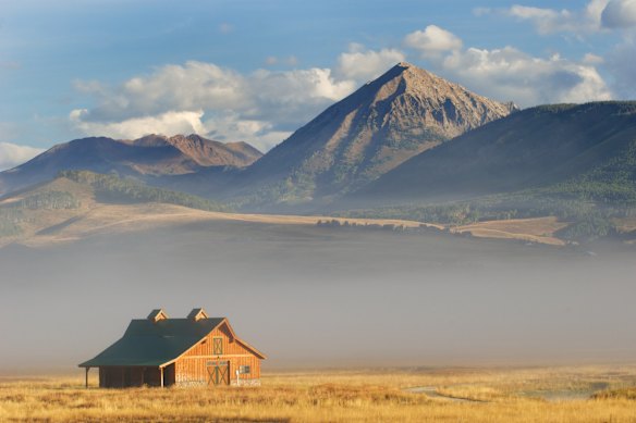 A lonely barn in shadows of the Rocky Mountains, near the village of Crested Butte, Colorado.