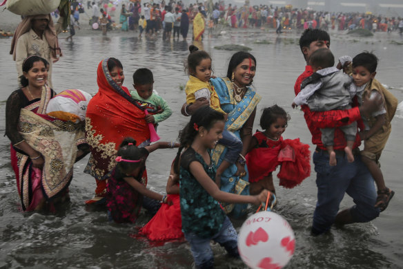 An Indian Hindu family walks on the shallow banks of the Yamuna river during Chhath Puja festival in New Delhi.