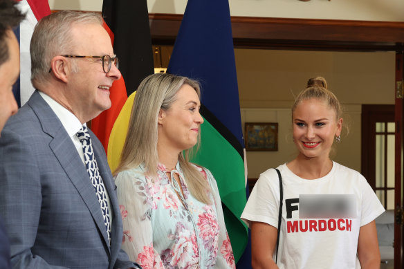 Grace Tame (right) greets Prime Minister Anthony Albanese and his fiancee, Jodie Haydon, at the Lodge while wearing a T-shirt emblazoned with the slogan “F--- Murdoch”.