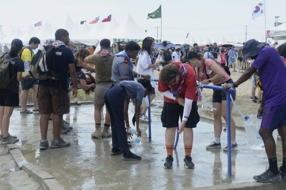 Attendees cool off with water at the camp site.