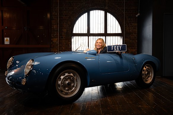 Hannah Fox with one of the Fox family’s custom number plates at the Fox Classic Car Collection in Docklands. Pictured with one of her favourite cars in the collection, a Porsche 550 RS Spyder. VicRoads are announcing 7 character plates with a limited release of 12 prestige plates in May.