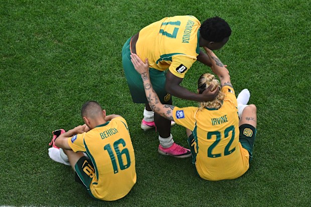 Shattered Socceroos Nestory Irankunda, Jackson Irvine and Aziz Behich after the loss to Egypt.