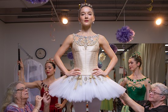 Volunteers Naomi Otton and Marcia Bergh put the finished touches on dancer Benedicte Bemet’s dress.