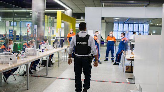 Border police and members of the civil protection ambulance service check the vaccination status and details of arriving passengers at Paris-Charles de Gaulle airport in Paris. 