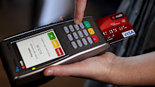 Eric Duong, manager of Malaysian restaurant Man Mo, poses for a photo performing a credit card transaction on July 31, 2014 in Melbourne, Australia.