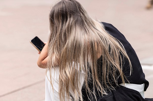 A woman looks at her mobile.
