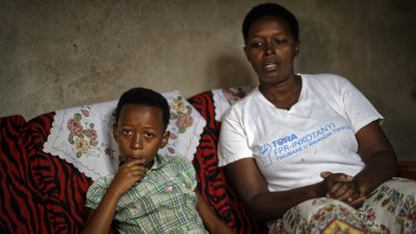 Genocide survivor Jannette Mukabyagaju, 42, recounts her experience as her daughter Natasha Umutesi, 8, listens, in their home in the reconciliation village of Mbyo​.
