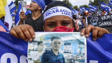 A protestor holds a photo of one of the victims of the deadly protests during an anti-government march in Managua.