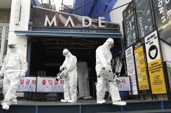 Workers spray disinfectant in Seoul.