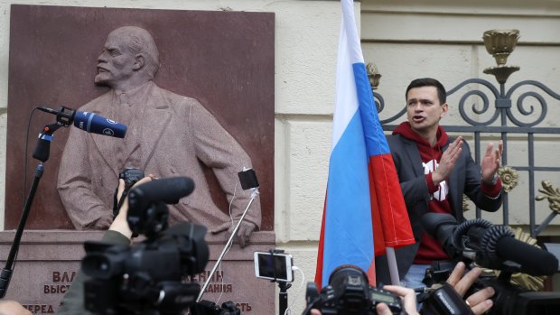 Russian opposition candidate and activist Ilya Yashin, right, speaks to a crowd next to a bas-relief of the Soviet founder Vladimir Lenin during a protest in Moscow.