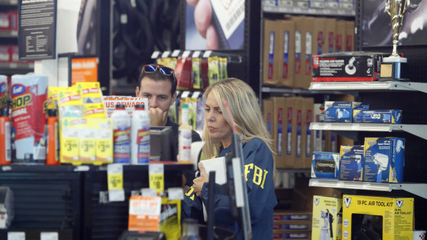 An FBI agent interviews staff at an Auto Zone auto parts store in Florida as part of their investigations into Cesar Sayec jnr. 