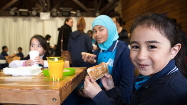 Ariana Alasi eats her toast at the free breakfast club at Campbellfield Public School.