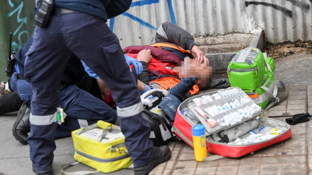 Paramedics attend to an overdose on Victoria Street last month.