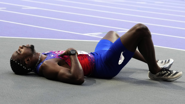 Noah Lyles lies on the track after finishing third in the men’s 200m in Paris.