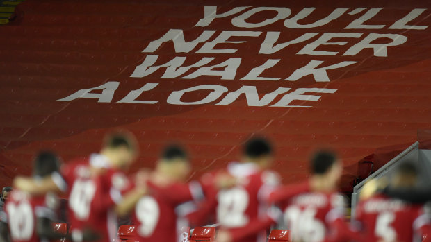 Liverpool players observe a minutes silence in memory of former England player Nobby Stiles in front of A You'll Never Walk Alone banner.