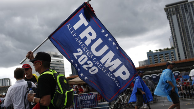 An attendee holds a campaign flag ahead of Trump's re-election launch in Orlando, Florida.