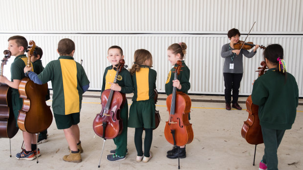 Violinist Aiko Goto, from the Australian Chamber Orchestra, with children from St Mary's North Public School.