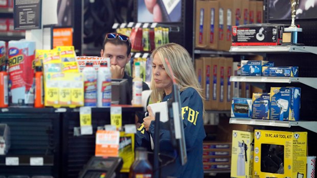 An FBI agent interviews staff at an Auto Zone auto parts store in Florida as part of their investigations into Cesar Sayoc. 