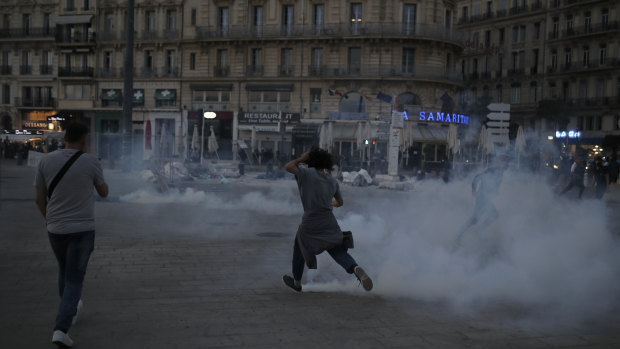 A protester runs among tear gas during a demonstration in Marseille.