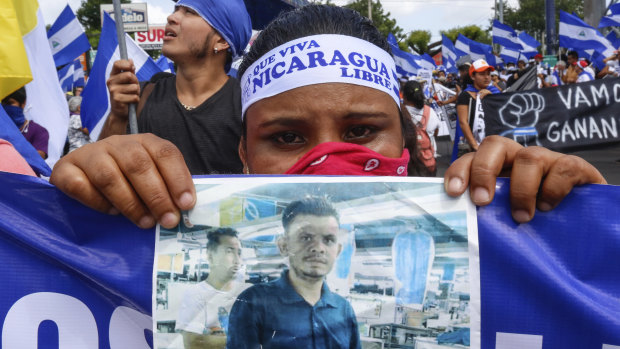 A protestor holds a photo of one of the victims of the deadly protests during an anti-government march in Managua.