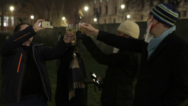 People raise a glass and celebrate in Parliament Square as the bell known as Big Ben strikes 2300, and Britain ends its transition period and formally leaves the European Union in London.