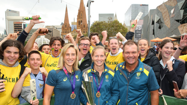 Ellyse Perry (left), with Meg Lanning and coach Matthew Mott, with the T20 World Cup trophy.