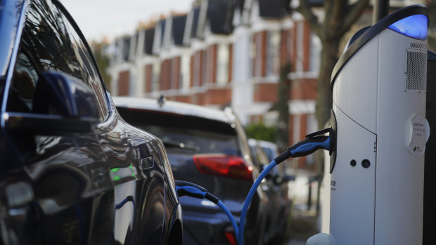 An electric car charges on a street charging port in London.