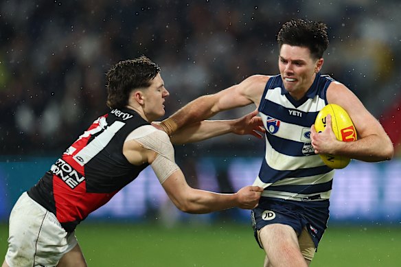 Archie Roberts of the Bombers tackles Oliver Henry of the Cats.