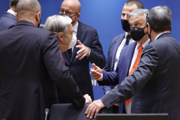 UN Secretary-General Antonio Guterres, partially seen left, and other leaders talk to Hungarian Prime Minister Viktor Orban, second right. 