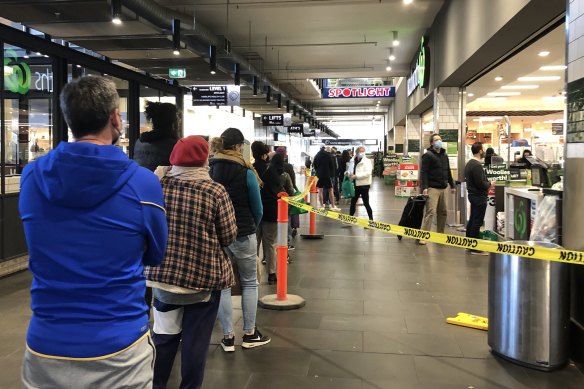 A long queue forms outside Woolworths supermarket in South Melbourne on Sunday.