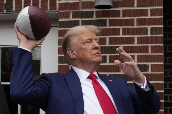 Former President Donald Trump prepares to throw a football to the crowd in Iowa State University in September.