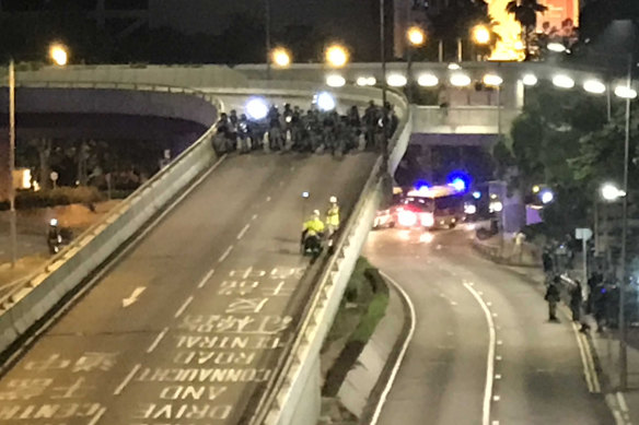 Tong Hua, 58, in his wheelchair speeding away from riot police on Harcourt Road.