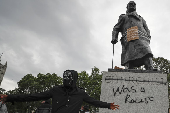 Protesters hung a sign and painted "racist" on the Winston Churchill statue in Parliament Square during the Black Lives Matter protest in London.