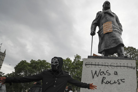 Protesters hung a sign and painted "racist" on the Winston Churchill statue in Parliament Square during the Black Lives Matter protest rally in London.