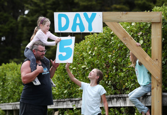 The Paddison family updates their roadside isolation countdown sign in Kaipara Flats, Auckland, on Tuesday.