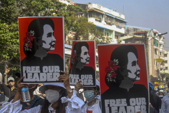 Anti-coup protesters display pictures of deposed Myanmar leader Aung San Suu Kyi in Yangon on Tuesday.