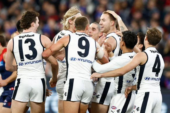 Harry McKay is mobbed by teammates after a goal.