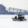 A US Coast Guard boat heads toward the collapsed Francis Scott Key Bridge wreckage.